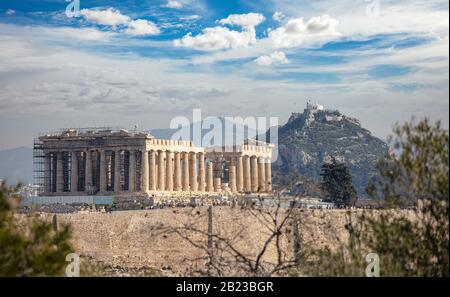 Athen, Griechenland. Akropolis Parthenon Tempel vom Philopappos Hügel aus gesehen, blau bewölkt Himmel. Lycabettus-Hügel-Hintergrund Stockfoto