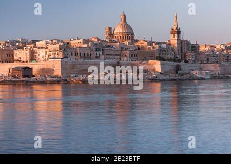 Valletta mit Unserer Lieben Frau von der Kirche Mount Carmel und der anglikanischen Pro-Cathedral von St. Paul bei Sonnenaufgang von Sliema, Valletta, Malta aus gesehen Stockfoto