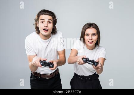 Foto eines kaukasischen Ehepaares Mann und Frau, die Videospiele mit Joysticks spielen Stockfoto