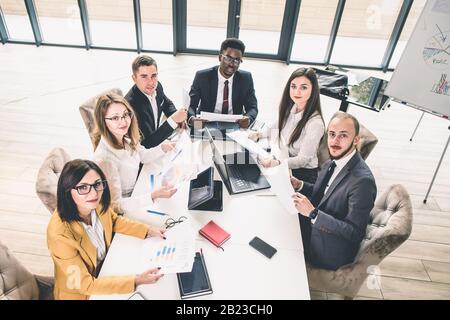 Multiethnische Gruppe von Geschäftsleuten, die ein Geschäftstreffen führen. Erfolgreiches Business Team im Büro. Draufsicht Stockfoto