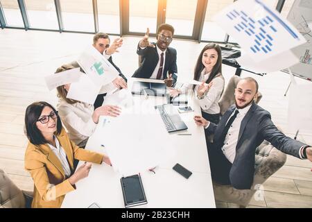 Multiethnische Gruppe von Geschäftsleuten, die ein Geschäftstreffen führen. Erfolgreiches Business Team im Büro. Draufsicht Stockfoto