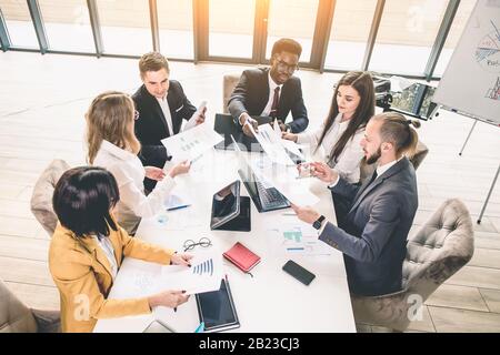 Multiethnische Gruppe von Geschäftsleuten, die ein Geschäftstreffen führen. Erfolgreiches Business Team im Büro. Draufsicht Stockfoto