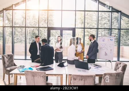 Geschäftsleute Haben Vorstandssitzung Im Modernen Büro. Multiethnische Gruppe junger erfolgreicher Geschäftsleute, die ein Geschäftstreffen haben Stockfoto