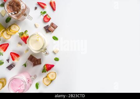 Drei Maurer-Gläser mit Milchshakes oder Smoothie. Sommer gesundes Frühstück, Mittagessen Getränke - Bananen, Schokolade und Erdbeermilchshakes auf Holzbackgroun Stockfoto