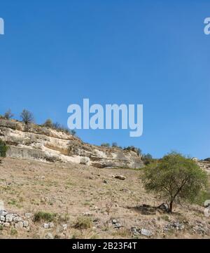 Blick auf die Klippen der Stadtfestung Chufut-Kale vom Balken Maryam-Dere im frühen Herbst. Ein warmer Sonnentag Stockfoto