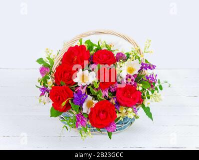 Blumenstrauß mit Gartenblumen in einem Vintage-Korb auf weißem Hintergrund Stockfoto