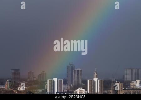 London, Großbritannien. Februar 2020. Wetter in Großbritannien: Ein massiver Regenbogen bricht nach einem kurzen Regensturm am Nachmittag über Südost-London. Credit: Guy Corbishley/Alamy Live News Stockfoto