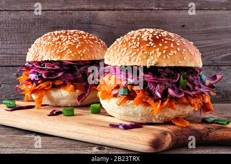 Pfropfige, fleischlose Burger mit Rotkohlslaw vor Holzhintergrund. Gesundes Essen, pflanzliches Fleischersatzkonzept. Stockfoto