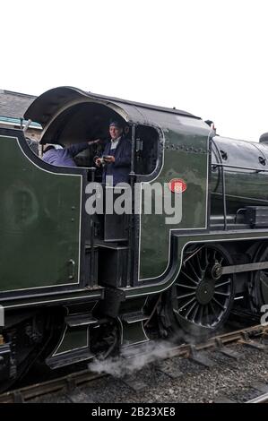 Ein Dampfmaschinenfahrer auf der Fußplatte der Dampflok, Nr.: 75029. Es ist "The Green Knight" am Bahnhof Grosmont, Teil der NYMR (Nord Stockfoto