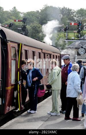 Passagiere, die im Dampfzug am Bahnhof Grosmont der North York Moors Railway (NYMR) in den North York Moors, Großbritannien, einsteigen Stockfoto