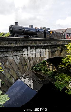 Die 1925 gebaute Dampflok 7F 2-8-0 Nr. 53809 schleppt eine Flotte von Kutschen und überquert eine kleine Flussbrücke, während sie Grosmont zur Pickering verlässt Stockfoto