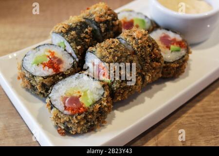 Heiße gebratene Sushi-Rolle mit Thunfisch, Avocado und Käse. Sushi-Menü. Japanische Küche. Stockfoto