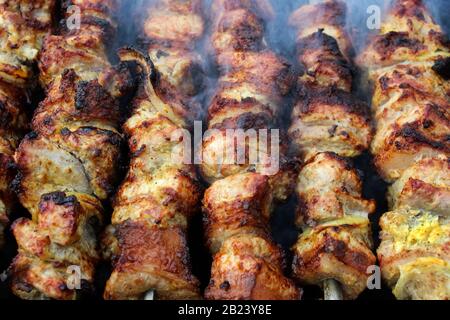 Kebabs auf Spießen, die in den Kohlen auf dem Grill geröstet wurden Stockfoto