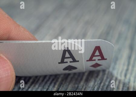 Tiefwinkel-Nahansicht einer männlichen Hand, die Karten von einem Casino-Tisch abholt und zeigt Stockfoto