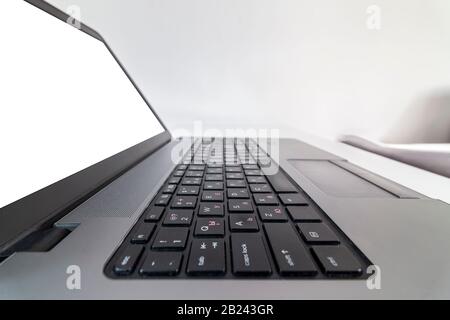 Makroansicht mit niedrigem Winkel der Laptop-Tastatur mit leerem Bildschirm auf einem Tisch Stockfoto