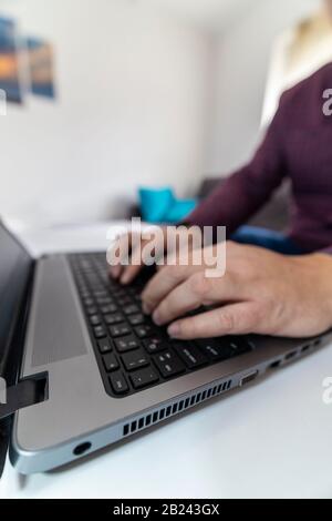 Fluchtkonzept. Niedrige Sicht auf einen Mann, der die Escape-Taste auf einer Laptop-Tastatur drückt. Stockfoto
