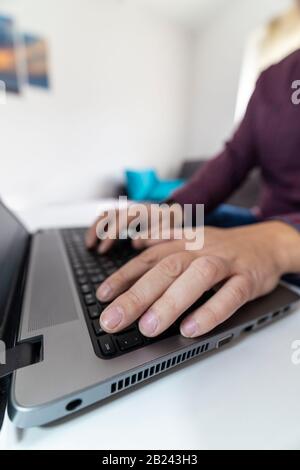 Fluchtkonzept. Niedrige Sicht auf einen Mann, der die Escape-Taste auf einer Laptop-Tastatur drückt. Stockfoto