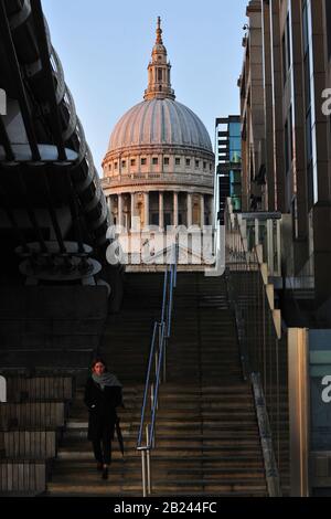 St Paul's Cathedral, London. Mit einer Person im Vordergrund, die die Treppe zur Millennium Bridge aufsteigt. Stockfoto