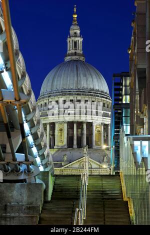 Ein starkes dynamisches Bild von Londons Wahrzeichen St Paul's Cathedral Nachts Abenddämmerung mit der Millennium Bridge im Vordergrund Stockfoto