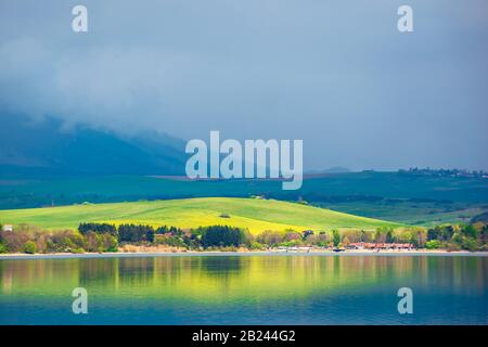 See in den Bergen. Bewölkter Tag im Frühling. Ländliche Felder auf sanften Hügeln. Schöne Landschaft der hohen tatra-berge in dappeliertem Licht. Wunderschöne Länder Stockfoto