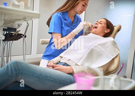 Zahnärztin, die mit der Patientin in der Klinik arbeitet Stockfoto