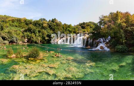 Touristen, die am Wasserfall Skradinski Buk, Nationalpark Krka, Region Sibenik-Knees, Dalmatien, Kroatien baden Stockfoto