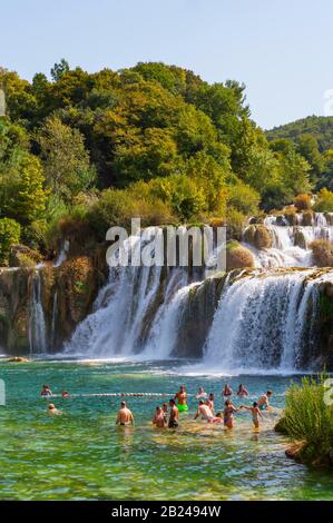 Touristen, die am Wasserfall Skradinski Buk, Nationalpark Krka, Region Sibenik-Knees, Dalmatien, Kroatien baden Stockfoto