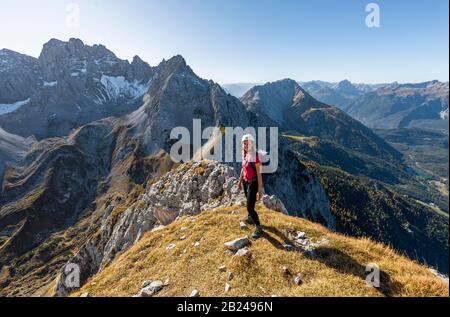 Junge Frau, Bergsteigerin mit Kletterhelm mit Blick auf die Berglandschaft, Wanderung zur Ehrwalder Sonnenspitze, hinter Gruenstein und West Stockfoto