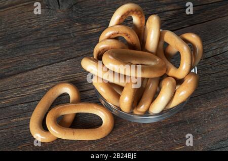 Leckere ovale Bagels in einer Glasschale auf altem Holzhintergrund Stockfoto