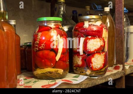 Glasflaschen mit selbstgebackenen Paprika auf einem Regal in einem Keller in Ungarn Stockfoto