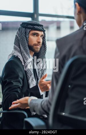 Arabischer Geschäftsmann spricht mit Partner über Treffen im modernen Büro Stockfoto