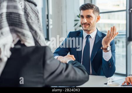 Positive multiethnische Geschäftsleute schütteln die Hände auf das Treffen Stockfoto