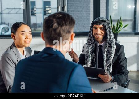 Glückliche multikulturelle Geschäftspartner, die den Vertrag über ein Treffen mit Übersetzern im Büro besprechen Stockfoto