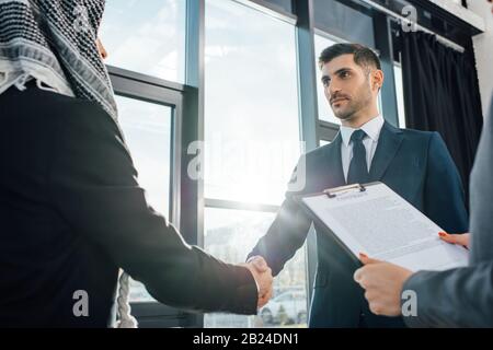 Arabischer Geschäftsmann schüttelt mit dem Partner die Hände, um sich mit dem Übersetzer im Büro zu treffen Stockfoto