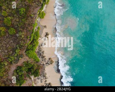 Blick auf den wunderschönen Strand mit Felsen und Wellen, die ins Ufer, Bali, Indonesien, rollen Stockfoto