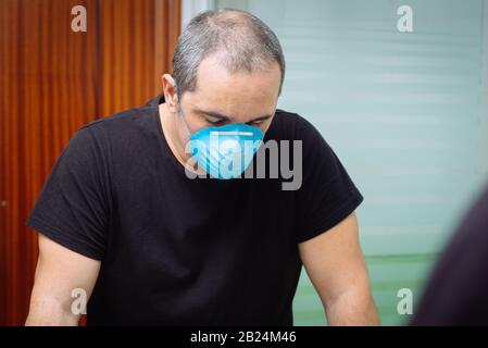 Porträt eines kranken Mannes, der eine hygienische Gesichtsmaske trägt. Coronavirus Konzept Stockfoto
