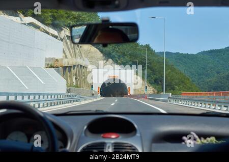 Auto, das sich während einer Fahrt auf einer Autobahn einem Tunnel nähert Stockfoto