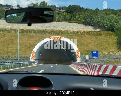 Eingang eines Tunnels, der von einem Auto während einer Fahrt aus gesehen wird Stockfoto