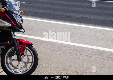 Nahaufnahme von Vorderrad, Scheinwerfer, Bremsscheibe, Stoßdämpfer. Motorrad auf der Straße. Stockfoto