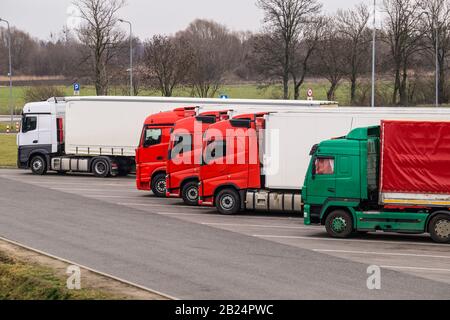 Rastplatz. Verschiedene Lkw-Typen auf dem Parkplatz neben der Autobahn. Stockfoto