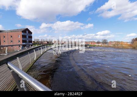 Die Holzfußbrücke über den Fluss Aire in Castleford mit Queens Mill Stockfoto