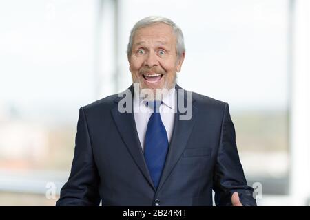 Äußerst glücklicher alter Geschäftsmann freut sich. Stockfoto