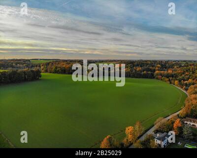 Blick auf die Landseite in Wallonien, Belgien, Luxusvillen und Bauernhaus, umgeben von Wald und Ackerland bei schönem Sonnenuntergang. Stockfoto