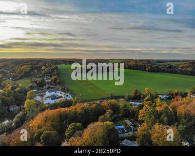 Blick auf die Landseite in Wallonien, Belgien, Luxusvillen und Bauernhaus, umgeben von Wald und Ackerland bei schönem Sonnenuntergang. Stockfoto