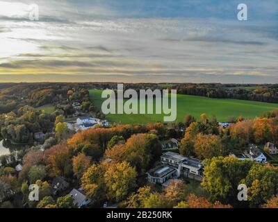 Blick auf die Landseite in Wallonien, Belgien, Luxusvillen und Bauernhaus, umgeben von Wald und Ackerland bei schönem Sonnenuntergang. Stockfoto