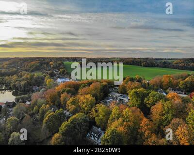 Blick auf die Landseite in Wallonien, Belgien, Luxusvillen und Bauernhaus, umgeben von Wald und Ackerland bei schönem Sonnenuntergang. Stockfoto