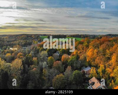 Blick auf die Landseite in Wallonien, Belgien, Luxusvillen und Bauernhaus, umgeben von Wald und Ackerland bei schönem Sonnenuntergang. Stockfoto