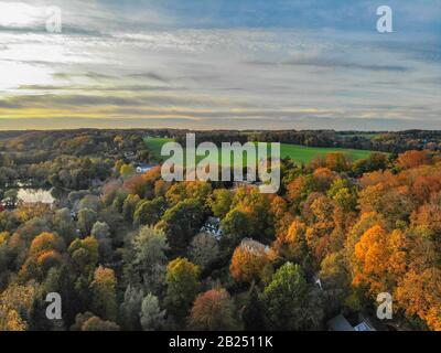 Blick auf die Landseite in Wallonien, Belgien, Luxusvillen und Bauernhaus, umgeben von Wald und Ackerland bei schönem Sonnenuntergang. Stockfoto