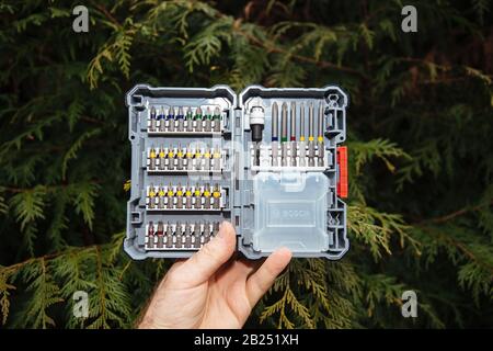 Paris, Frankreich - 23. Februar 2020: Mann Hand hält gegen grünen Baum Arborvitae Thuya occidentalis offene Box Neues Paket für Bosch professionelles Akkuschrauben-Zubehör Pick Click Set 40 Stück - hinteres Teil Stockfoto