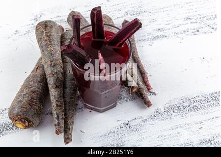 Traditioneller türkischer Getränkesaft (Salgam). Roter Karotten- und Rüssensaft auf weißem Holzhintergrund. Stockfoto